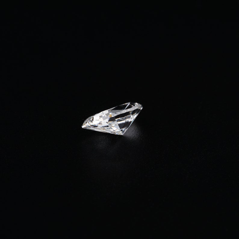 May include: A clear, round, faceted diamond gemstone on a black background.