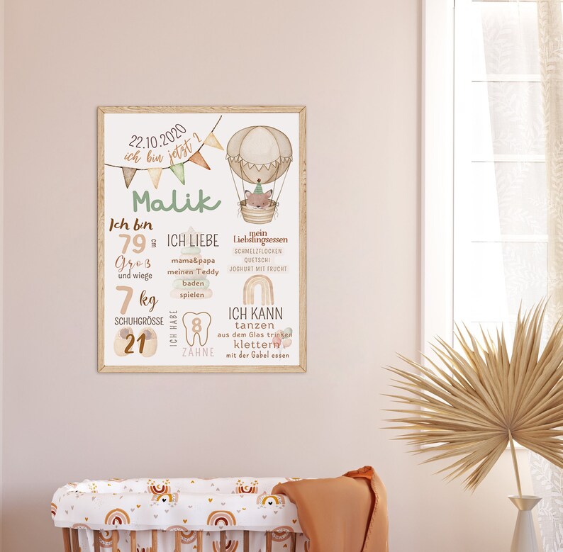May include: A colorful printable poster for a child's nursery or bedroom. The poster features a hot air balloon with a fox in it, and text that says "22.10.2020 ich bin jetzt 2 Malik". The poster also includes information about the child's age, size, weight, shoe size, and number of teeth.