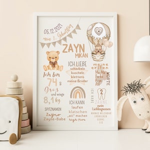 May include: A beige and brown illustrated baby milestone poster with a hot air balloon, teddy bears, and a rainbow. The poster features the name Zayn Mikan and the date 05.12.2021. The poster lists the baby's age, weight, height, first words, and other milestones.