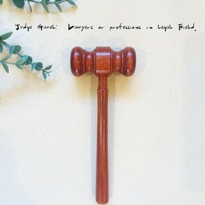 May include: A wooden judge's gavel with a brown handle. The gavel is a symbol of authority and justice, often used in courtrooms and legal proceedings. "Judge Gavel: Lawyers or professions in legal field."
