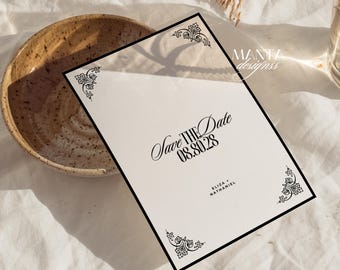 May include: A cream-colored "Save the Date" card with black decorative corner designs and a black border. The card features the text "Save the Date" and the date "08.30.28". The names "Eliza" and "Nathaniel" are also printed on the card.
