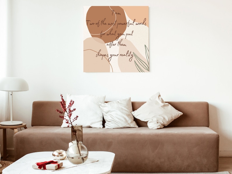 May include: A beige and brown abstract art print with a quote that reads "Two of the most powerful words for what you put after them shapes your reality."