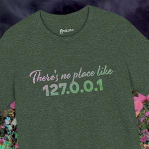 May include: Green t-shirt with the text "There's no place like 127.0.0.1" in a gradient of pink and green. The word "geekists" is printed above the text. The shirt is a solid green color.