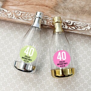 May include: Two clear plastic champagne bottle favors with silver and gold accents. Each bottle has a sticker with the number 40 and the text "Stella's Birthday Party 9.22.25".