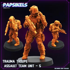 May include: Three orange plastic miniature figures of soldiers wearing futuristic armor and helmets, holding weapons. The figures are standing on black bases. The text "Trauma Troupe Assault Team Unit - 5" is printed below the figures.