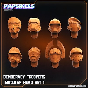 May include: An assortment of eight orange-brown modular head designs for Democracy Troopers. The heads feature various helmet styles, including visors, berets, and full-face coverings. The text "Papsikels" and "Democracy Troopers Modular Head Set 1" are visible.