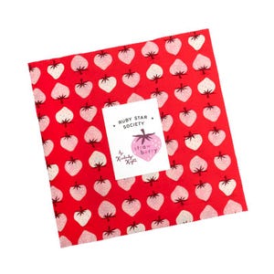 May include: A square fabric piece with a red background and a repeating pattern of white and pink strawberries. A white label with the text "RUBY STAR SOCIETY" and a pink strawberry illustration is centered on the fabric.