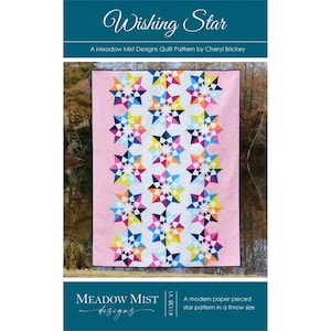 May include: A colorful quilt with a pink background features a repeating star pattern in shades of blue, pink, yellow, and white. The quilt is labeled "Wishing Star" and is a Meadow Mist Designs quilt pattern by Cheryl Brickey.