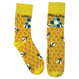 May include: A pair of yellow socks with a honeycomb pattern and cartoon bees. The socks have a yellow cuff and toe. The text "I'll Bee Quilling" and "moda" are printed on the socks.
