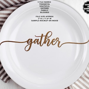 May include: A white plate featuring the word gather in a brown wood grain script font. Text above reads 5 FILE NAMES THANKFUL GRATEFUL GATHER FAMILY BLESSED and FILE SIZE APPROX 3" H x 11.8" W SAMPLE MOCKUP ON WOOD. A black badge reads SVG PNG EPS DOWNLOAD FILES.