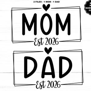 May include: Black and white graphic design featuring the words "MOM" and "DAD" with "Est 2026" underneath each word. A heart is above each word. The design is enclosed in a rectangular frame. The top of the image reads "2 FILES - 1 MOM - 1 DAD".