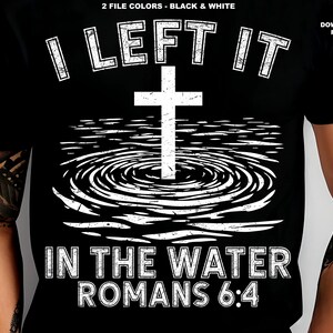 May include: Black t-shirt with a white graphic featuring a cross in water, the text "I LEFT IT IN THE WATER ROMANS 6:4", and the words "2 FILE COLORS - BLACK & WHITE" and "SVG PNG DOWNLOAD FILES".