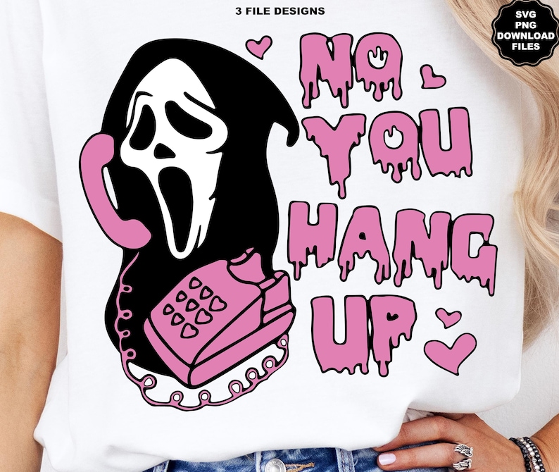 Puede incluir: Camiseta blanca con un gr&aacute;fico rosa y negro de un personaje de cara de fantasma sosteniendo un tel&eacute;fono rosa. El texto "NO YOU HANG UP" est&aacute; en letras rosas goteando, con corazones rosas. El dise&ntilde;o es una descarga digital.