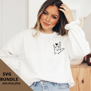 May include: White sweatshirt featuring a black graphic of a hand signing 'I love you' in British Sign Language. The hand is holding a small black heart.