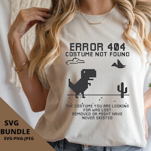Peut inclure: T-shirt beige avec un motif de dinosaure pixélisé noir et le texte "ERROR 404 COSTUME NOT FOUND". Le t-shirt comprend également le texte "THE COSTUME YOU ARE LOOKING FOR WAS LOST REMOVED OR MIGHT HAVE NEVER EXISTED".