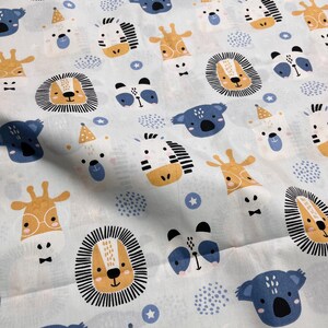 May include: A light blue fabric featuring a repeating pattern of cartoon animal faces including lions with black manes, blue koalas, giraffes with glasses, zebras, and white bears wearing yellow party hats, interspersed with small blue stars and dots.