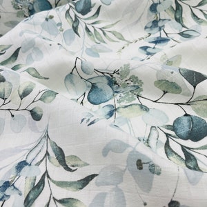 May include: White fabric with a blue and green watercolour floral pattern. The pattern features leaves and flowers in shades of blue and green.