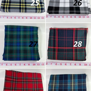May include: Six folded fabric swatches with plaid patterns labeled 25 through 30. Each swatch is positioned above a measuring tape showing inches. The patterns include gray with yellow, black and white, green and blue, dark green with red, red, and blue.