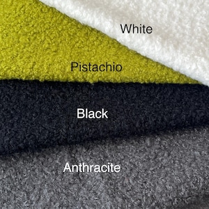 May include: Close-up of fabric samples in white, pistachio, black, and anthracite. The fabric has a textured, looped appearance. The colours are labelled with white text.