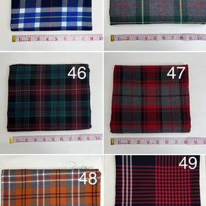 May include: A collection of six folded fabric swatches featuring various plaid patterns labeled 44 through 49. Each swatch is positioned above a measuring tape showing widths between 9 and 11 inches. The patterns include blue, green, red, and orange.