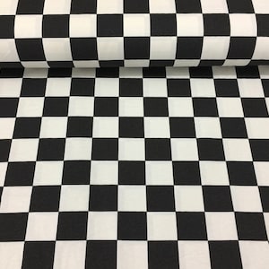 May include: Black and white checkered fabric with a large square pattern. The fabric is folded in half, showing the back side.
