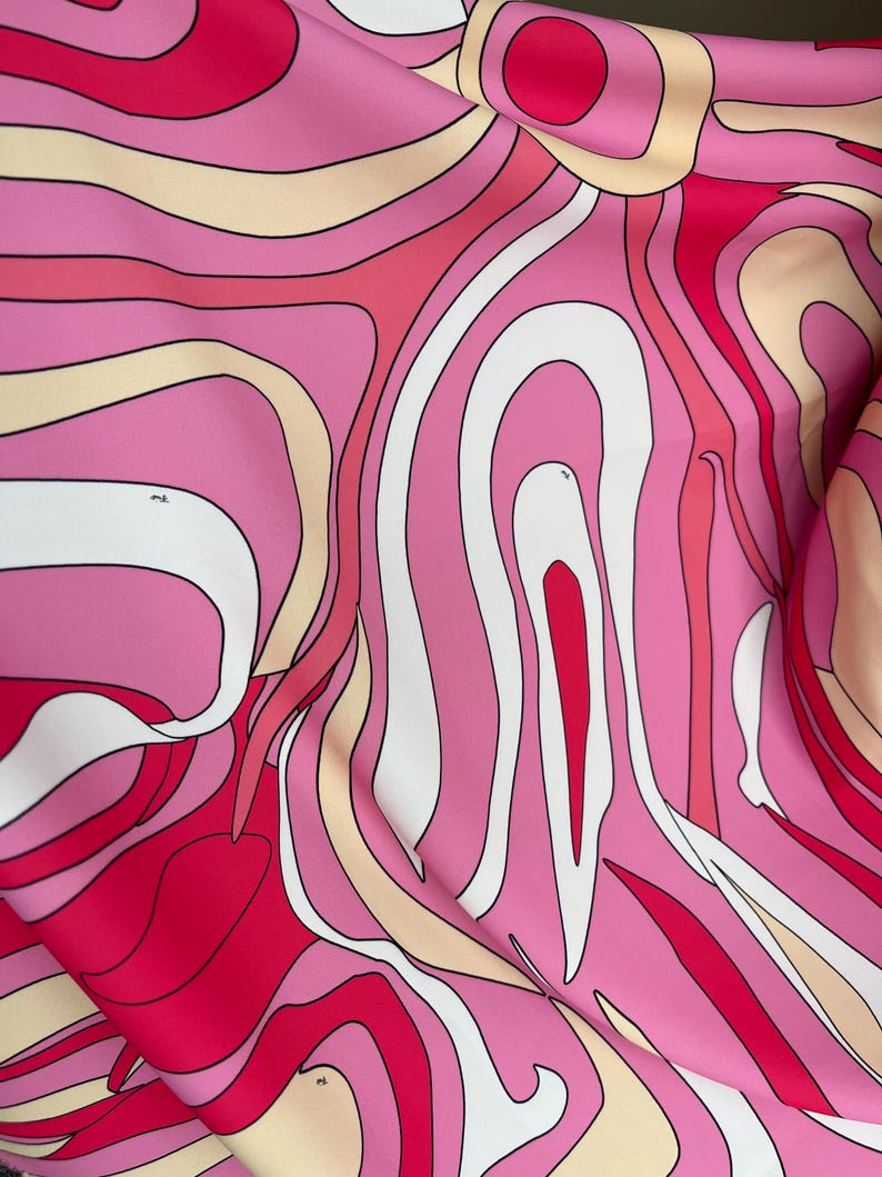 Puede incluir: Primer plano de una tela con un dise&ntilde;o abstracto. El patr&oacute;n presenta l&iacute;neas curvas y fluidas en tonos de rosa, blanco, rojo y beige, creando un efecto psicod&eacute;lico. La tela parece suave, posiblemente seda o sat&eacute;n.