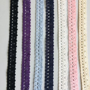 Peut inclure: Plusieurs rubans de dentelle crochetée aux couleurs variées : noir, violet, bleu clair, marine, blanc, rose et crème. Les rubans présentent un motif ajouré délicat, idéal pour l'artisanat et les embellissements.