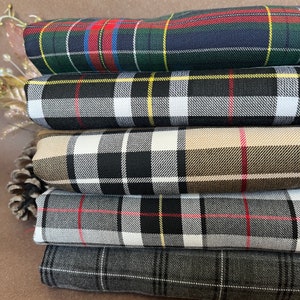 May include: A stack of five plaid fabrics in different colours and patterns. The fabrics are arranged from top to bottom with the darkest fabric on top and the lightest fabric on the bottom. The fabrics are all plaid and have a variety of colours, including red, green, blue, black, white, and yellow.