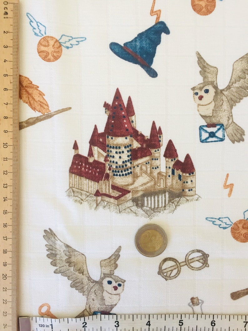 May include: White fabric with a repeating pattern of Harry Potter themed illustrations. The pattern includes Hogwarts castle, owls, a golden snitch, a wizard's hat, and a lightning bolt.