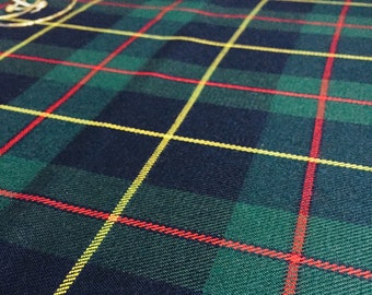 May include: Close-up of a green, navy, red, and yellow plaid fabric. The fabric has a woven texture and a classic tartan pattern. The colors are arranged in a grid-like design, creating a traditional look. The fabric is likely used for clothing or home decor.