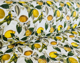 May include: White fabric with a repeating pattern of yellow lemons, green leaves, and butterflies. The fabric has a subtle texture.