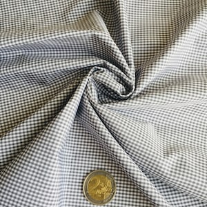 May include: White and grey gingham fabric with a small check pattern. A Euro coin is placed on the fabric for scale.