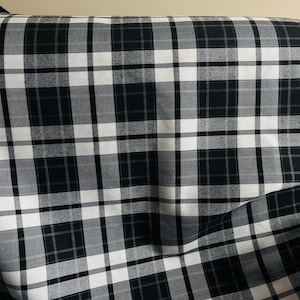 May include: A white ceramic mug with a black handle and the text "But First, Coffee" in a bold, black font. The mug is sitting on a wooden surface. The mug is approximately 4 inches tall.