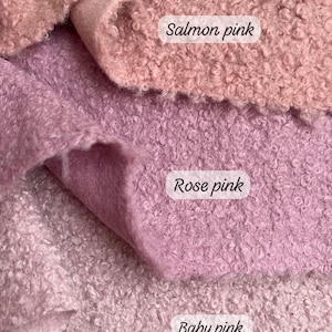 May include: Close-up of three fabric swatches in shades of pink. The top swatch is salmon pink, the middle is rose pink, and the bottom is baby pink. The colour names are written on the fabric.