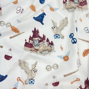 May include: White fabric with a repeating pattern of Harry Potter themed illustrations. The pattern includes Hogwarts castle, owls, glasses, potions, and the number "9 3/4".