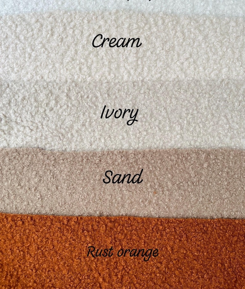 May include: Image showing four fabric samples in cream, ivory, sand, and rust orange. The colours are labelled in cursive. The fabrics have a textured, fluffy appearance, suggesting a soft, warm material.
