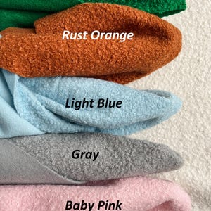 Może przedstawiać: Pięć pr&oacute;bek tkaniny w r&oacute;żnych kolorach: zielony szmaragd, pomarańczowy rdza, jasnoniebieski, szary i r&oacute;żowy. Tkanina ma puszystą fakturę.