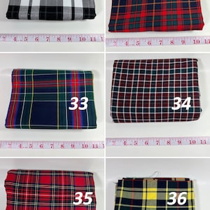 May include: Six folded fabric swatches labeled 31 through 36, each featuring distinct plaid patterns in various color combinations. A white measuring tape is positioned below each swatch, showing widths ranging from approximately 9 to 11 inches.