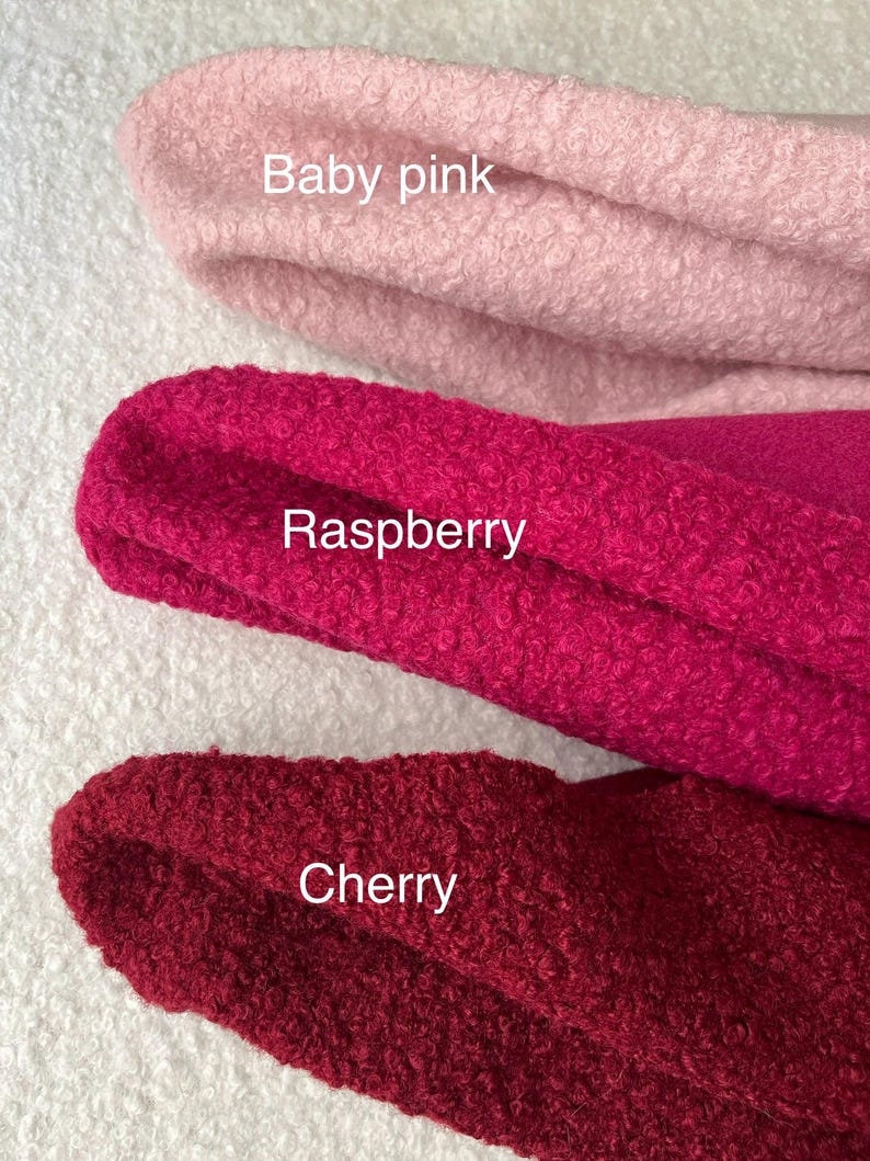 May include: Close-up of three fabric swatches in baby pink, raspberry, and cherry colours. The fabric has a textured, looped appearance. The colour names are written on the fabric.