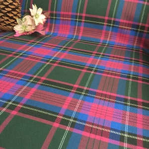 May include: Green, pink, blue, and white plaid fabric with a subtle sheen. The fabric has a woven texture.