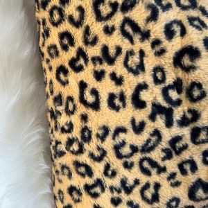 Könnte beinhalten: Nahaufnahme eines braunen und schwarzen Kunstpelzes mit Leopardenmuster.