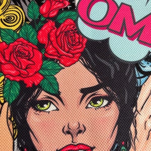 May include: A colorful illustration of a woman with red roses in her hair. The woman has green eyes and red lips. The background is a comic book style with the word "OM" in a speech bubble.