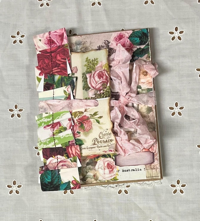 Pu&ograve; includere: Un diario fatto a mano con un nastro rosa legato intorno. La copertina &egrave; decorata con carta a motivi floreali, pizzo e un nastro rosa. Il diario ha un'estetica vintage ed &egrave; perfetto per tenere un diario, fare scrapbooking o altri progetti creativi.