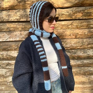 May include: A white ceramic mug with a black handle and the text "But First, Coffee" in a handwritten style. The mug is on a white surface. The mug is approximately 4 inches tall.