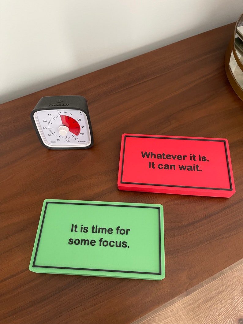 May include: Two motivational signs with black text on a colorful background. The green sign reads "It is time for some focus." The red sign reads "Whatever it is. It can wait."