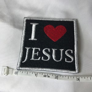 Op de afbeelding: Geborduurde patch met de woorden "I LOVE JESUS" in witte draad op een zwarte achtergrond. Een rood hart is geborduurd boven het woord "JESUS". De patch is ongeveer 6,35 cm vierkant.