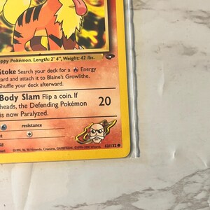 以下が含まれることがあります： オレンジと黒の犬のような生き物、ガーディのポケモンカード。カードには「Body Slam」や「Stoke」などのテキストがあります。カードの長さは71cm、重さは19kgです。