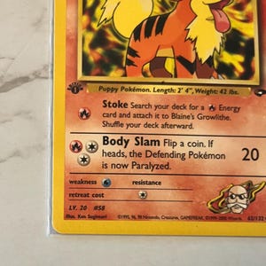 以下が含まれることがあります： オレンジと黒の毛並み、黄色のたてがみ、ピンクの舌を持つ漫画の犬が描かれたポケモンカード。カードには、「Body Slam」や「Stoke」など、キャラクターの能力とステータスを説明するテキストが含まれています。カードはLV. 20です。