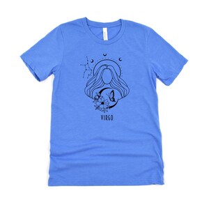 Puede incluir: Una camiseta azul claro con un gr&aacute;fico en blanco y negro de una mujer con el pelo largo, una mariposa y flores. El gr&aacute;fico tambi&eacute;n incluye el texto "VIRGO".