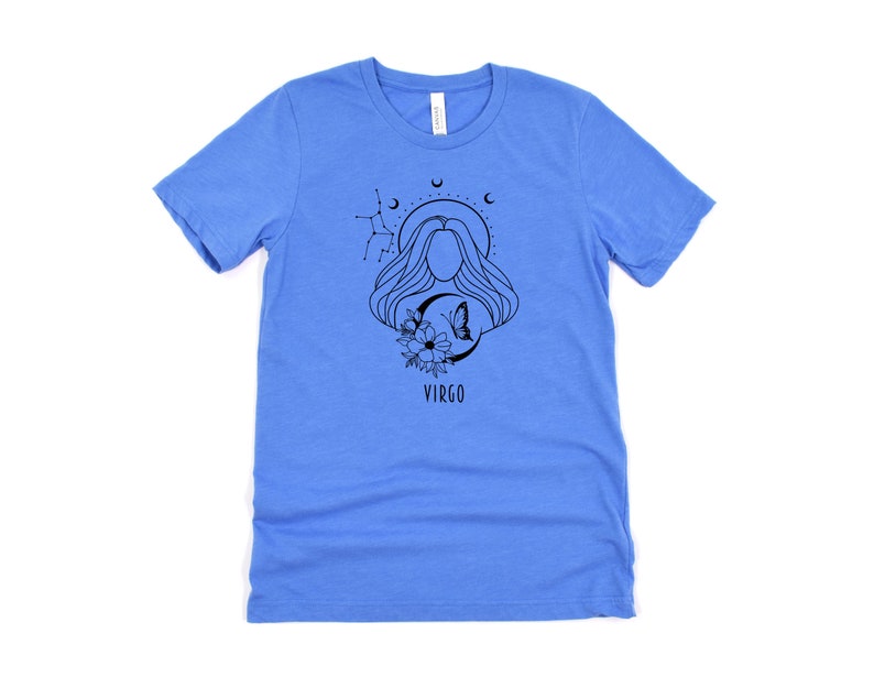 Puede incluir: Una camiseta azul claro con un gr&aacute;fico en blanco y negro de una mujer con el pelo largo, una mariposa y flores. El gr&aacute;fico tambi&eacute;n incluye el texto "VIRGO".